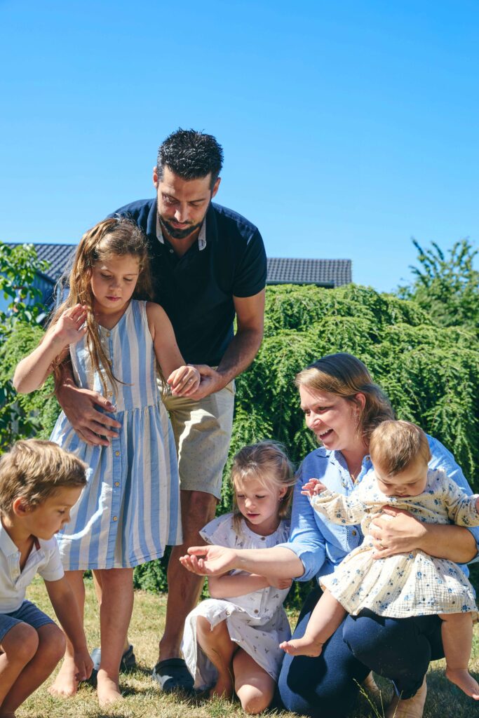 Große Familie mit Kindern beim gemeinsamen Spielen im Garten