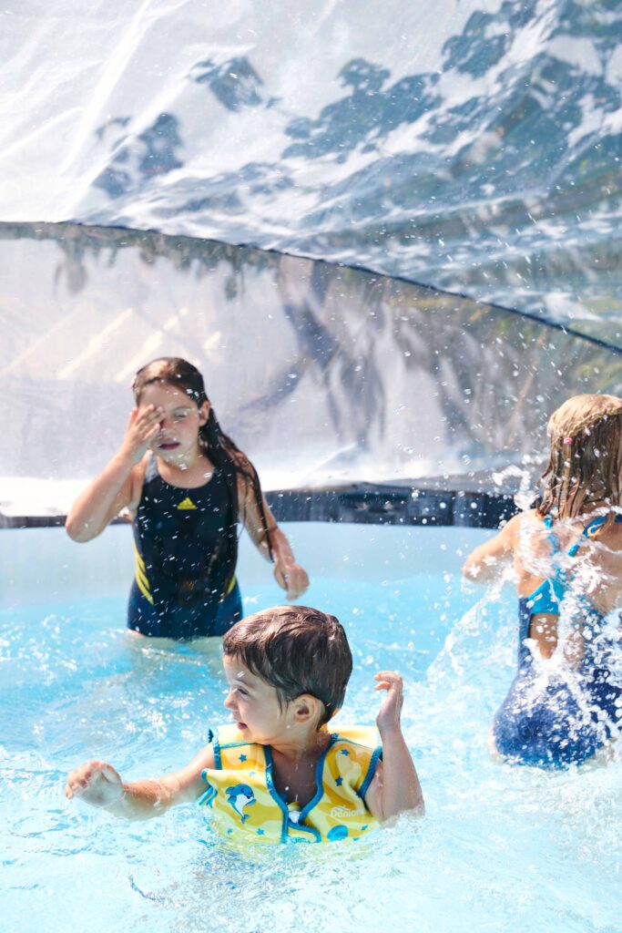 Familie mit Kindern beim gemeinsamen Spielen im Pool