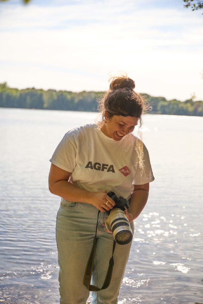 Hochzeits- und Familienfotografin Michaela Hayn mit Kamera am Wasser am Grüner See in Ratingen